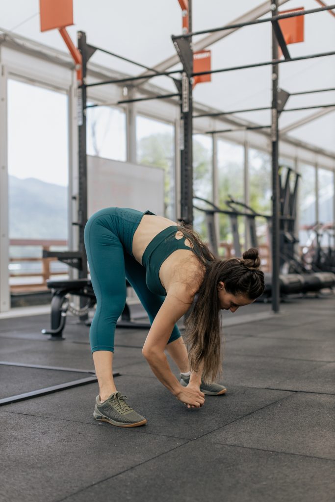 Femme sportive qui fait du yoga en posture de l'étirement intense pieds écartés | Sporty woman in a yoga pose, prasaritta padottanasana wide-stance forward bend